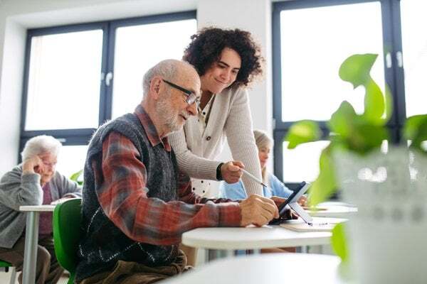 senior-communities-young-caregiver-helping-elderly-man-3